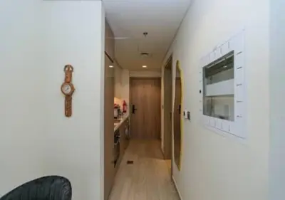 a hallway of a house with a clock on a wall at Stylish Meydan Studio with Private Balcony in Dubai