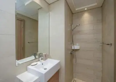 a bathroom with a sink and a shower with a mirror at Stylish Meydan Studio with Private Balcony in Dubai