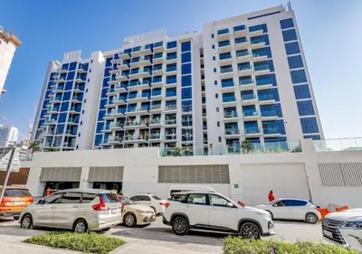 a parking lot with cars parked in front of a building at Stylish Meydan Studio with Private Balcony in Dubai