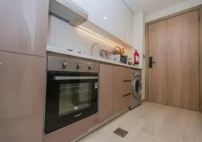 a kitchen with a stove and a washer and dryer at Stylish Meydan Studio with Private Balcony in Dubai