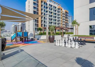a chess game in a courtyard in front of a building at Stylish Meydan Studio with Private Balcony in Dubai