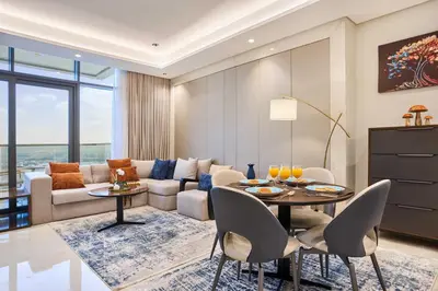 a living room with a couch and a table and chairs at Nobles Tower Business Bay - Modern 1-Bedroom Apartment in Dubai