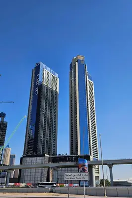 three tall buildings in a city with a street sign at Nasma Luxury stays- Lavish with luxury facilities in Aykon city in Dubai