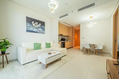 a living room with a white couch and a table at Vida Dubai Mall 1BR apt - Connected to Dubai Mall in Dubai