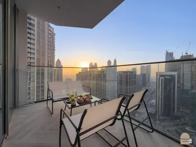 a balcony with chairs and a table with a view of a city at 35 eme étage panoramique vue mer ,vue Burj Khalifa et Burj el araabe in Dubai