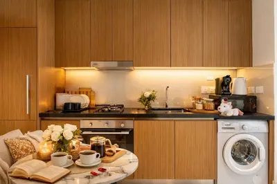 a kitchen with a table and a dishwasher at Luxury Studio with Pool and Parking at Azizi Vista in Dubai