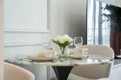 a table with plates and glasses and white flowers on it at Luxury Studio with Pool and Parking at Azizi Vista in Dubai