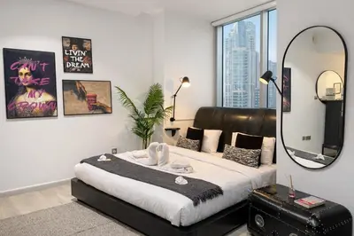a bedroom with a large bed and a mirror at Artistic Studio in Cayan Tower with Marina Views in Dubai