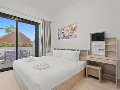 a bedroom with a bed and a tv and a balcony at Homely Bliss Studio in Azizi Riviera-12 in Dubai
