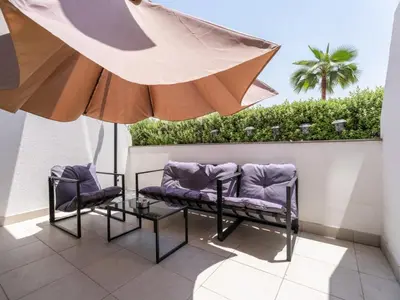 a patio with two chairs and an umbrella at Homely Bliss Studio in Azizi Riviera-12 in Dubai