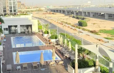an overhead view of a pool with chairs and umbrellas at Homely Bliss Studio in Azizi Riviera-12 in Dubai