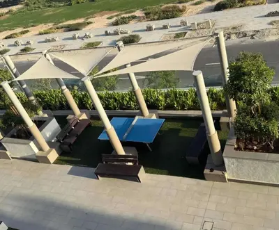 a patio with tables and umbrellas on a building at Homely Bliss Studio in Azizi Riviera-12 in Dubai