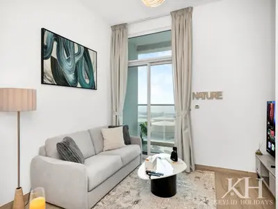 a living room with a couch and a large window at keylid Premium 1BR Apartment Dubai Marina in Dubai