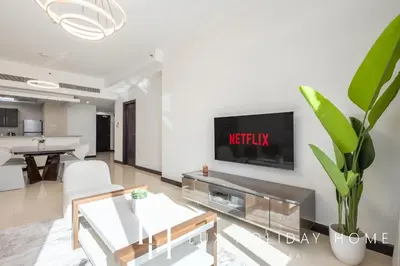 a living room with a tv on a wall at LUX The 02 Residences JLT Suite in Dubai