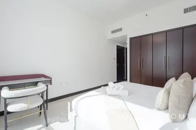 a bedroom with a white bed and a desk at LUX The 02 Residences JLT Suite in Dubai