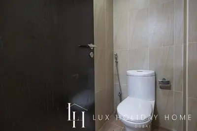 a bathroom with a white toilet in a bathroom stall at LUX The 02 Residences JLT Suite in Dubai