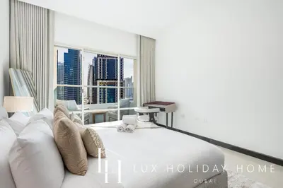 a bedroom with a white bed and a large window at LUX The 02 Residences JLT Suite in Dubai