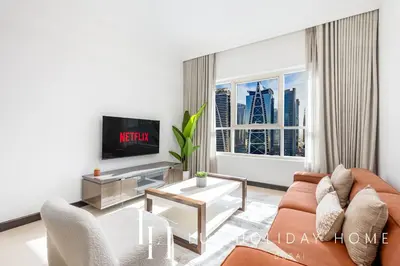 a living room with a couch and a tv at LUX The 02 Residences JLT Suite in Dubai