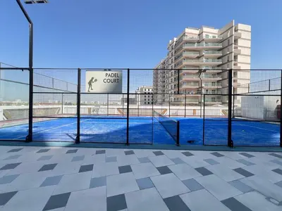 a view of a tennis court behind a fence at Exclusive Gemz Stay 2BR plus Study w Private Pool-07 in Dubai