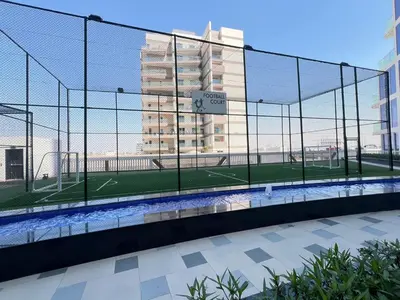 a tennis court in a batting cage in a building at Exclusive Gemz Stay 2BR plus Study w Private Pool-07 in Dubai