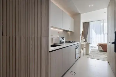 a kitchen with white cabinets and a counter top at Binghatti Phoenix - Luxury & Modern Studio - Pool & Gym - Free Parking - JVC in Dubai