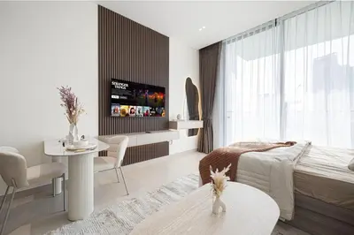 a bedroom with a bed and a table with a tv at Binghatti Phoenix - Luxury & Modern Studio - Pool & Gym - Free Parking - JVC in Dubai