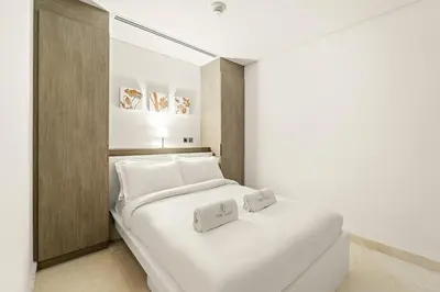 a bedroom with a white bed with two white pillows at FIRST CLASS 2BR Modern Luxury Hideaway in Dubai