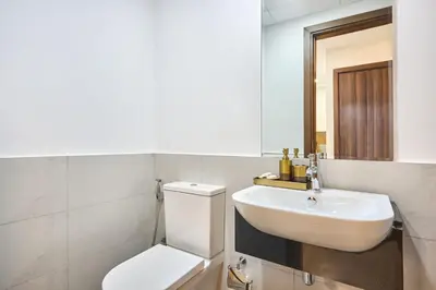 a bathroom with a sink and a toilet and a mirror at Modern 2-Bedroom Retreat in Remraam - Al Ramth 5 in Dubai