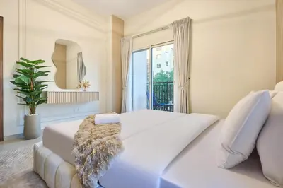 a bedroom with a white bed and a window at Modern 2-Bedroom Retreat in Remraam - Al Ramth 5 in Dubai