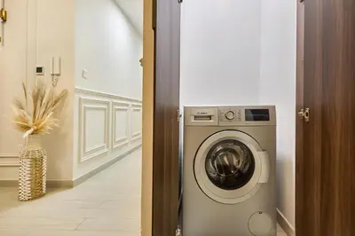 a laundry room with a washing machine in a hallway at Modern 2-Bedroom Retreat in Remraam - Al Ramth 5 in Dubai