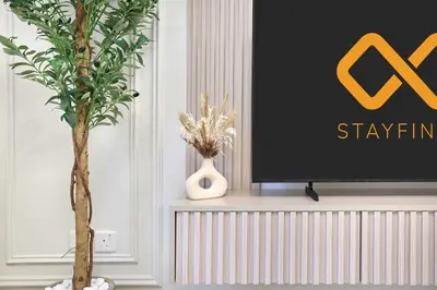 a tv sitting on a shelf next to a plant at Modern 2-Bedroom Retreat in Remraam - Al Ramth 5 in Dubai
