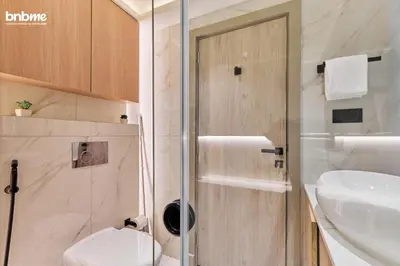 a bathroom with a shower and a toilet and a sink at bnbmehomes - Burj Al Nujoom in Dubai