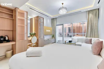 a bedroom with a large white bed and a large window at bnbmehomes - Burj Al Nujoom in Dubai