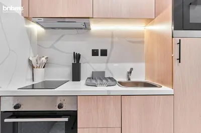 a kitchen with a sink and a microwave at bnbmehomes - Burj Al Nujoom in Dubai