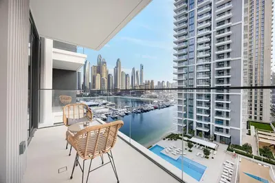 a balcony with two chairs and a view of a harbor at Blissful Living at Beach Mansion with Private Beach in Dubai