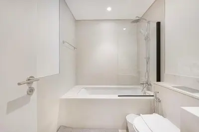 a white bathroom with a shower and a toilet at Blissful Living at Beach Mansion with Private Beach in Dubai