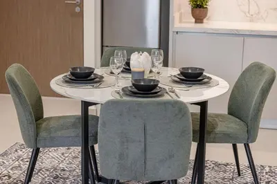 a dining room table with chairs and a white table with glasses at Blissful Living at Beach Mansion with Private Beach in Dubai