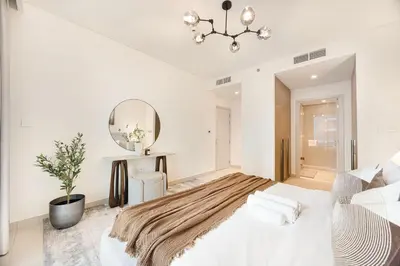 a white bedroom with a bed and a mirror at Blissful Living at Beach Mansion with Private Beach in Dubai