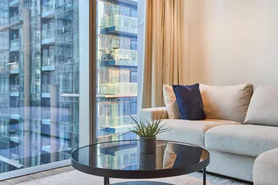 a living room with a couch and a glass table at Jumeirah Living Marina Gate - Elegant 1BR Canal View Retreat in Dubai