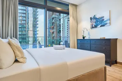 a bedroom with a large bed and a large window at Jumeirah Living Marina Gate - Elegant 1BR Canal View Retreat in Dubai