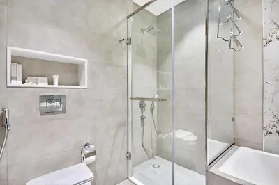 a bathroom with a shower and a toilet and a sink at Waterfront 2BR District One Residence - Near Downtown and Lagoon in Dubai