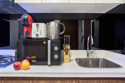 a kitchen counter with a sink and a microwave at Reva Residences 1BR - Near Downtown Dubai & Canal Walk in Dubai