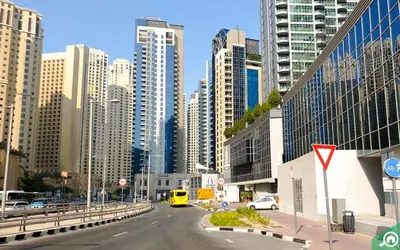 a city street with tall buildings and a yellow van at LMY Wharf 2 Marina View Suites - Dubai JBR Marina in Dubai