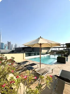 a swimming pool with an umbrella and tables and chairs at Purple Homes, City Walk Apartments in Dubai