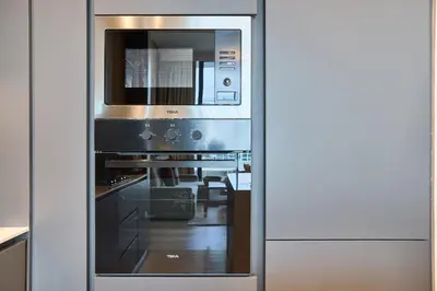 a microwave oven sitting inside of a kitchen at Stylish 1BR near Miracle Garden - Oxford Gardens in Dubai