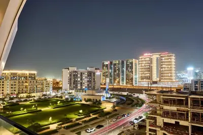 a view of a city at night with traffic at Stylish 1BR near Miracle Garden - Oxford Gardens in Dubai