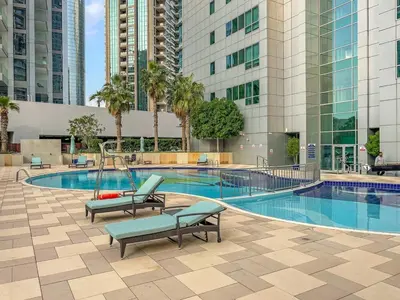 a swimming pool with two chairs and a swing at FIRST CLASS 1BR Panoramic Marina Views in Dubai