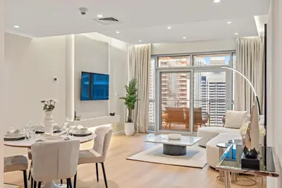 a white living room with a table and a couch at FIRST CLASS 1BR Panoramic Marina Views in Dubai