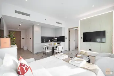 a living room with a white couch and a kitchen at Skyview Experience View Burj Khalifa Pool, Canal in Dubai