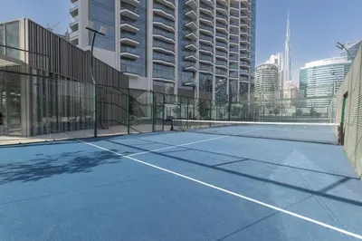 a tennis court in front of a building at Skyview Experience View Burj Khalifa Pool, Canal in Dubai